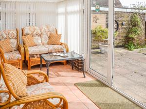eine überdachte Veranda mit Stühlen und einem Tisch in der Unterkunft Jenny's in Stalham