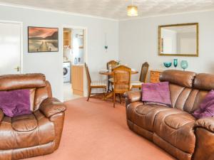 ein Wohnzimmer mit zwei Ledersofas und einem Tisch in der Unterkunft Jenny's in Stalham