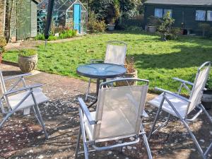 drei Stühle und ein Tisch in einem Garten in der Unterkunft Jenny's in Stalham + 9 Fotos