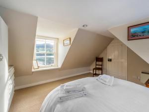 a bedroom with a white bed and a window at Faodail in Plockton