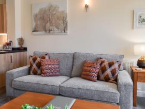 a living room with a gray couch with pillows at Swan House in Carnforth
