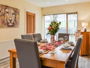 a dining room with a wooden table and chairs at Swan House in Carnforth