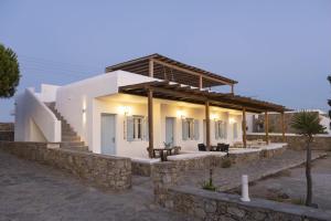 a white house with a stone wall at Lefkanemos in Tourlos