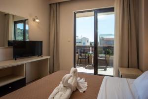 a hotel room with a towel animal on a bed at Santa Helena Hotel in Ialysos