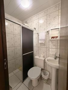 a bathroom with a toilet and a sink at Pousada Anjo Gabriel in Penha +103 photos