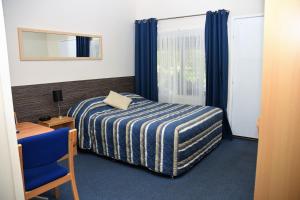 Un pat sau paturi într-o cameră la Chinchilla Motel