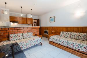 a living room with two couches and a kitchen at Curia Clube in Curia