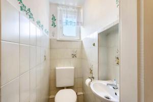 a white bathroom with a toilet and a sink at Ferienwohnung Coerdt Sauerland in Olsberg +20 photos
