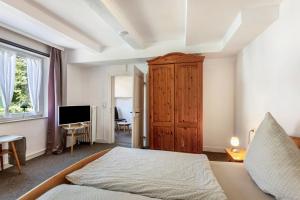 a bedroom with a bed and a wooden cabinet at Ferienwohnung Coerdt Sauerland in Olsberg