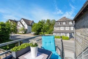 a balcony with a blue chair and a table at Ferienwohnung Coerdt Sauerland in Olsberg