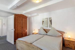 a bedroom with a large bed and a wooden cabinet at Ferienwohnung Coerdt Sauerland in Olsberg