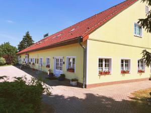 a yellow building with a red roof at Hotel-Pension Am Mühlberg in Lübbenau