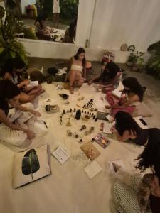 a group of people sitting on the floor playing with beads at LahSelva Pousada e Hostel in Itacaré
