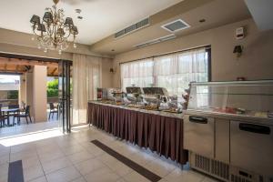 a restaurant with a counter with food on it at Santa Helena Hotel in Ialysos