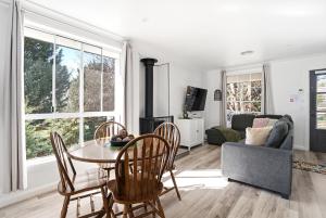 a living room with a table and chairs and a couch at Blue Willow Cottage - Bathurst in Bathurst