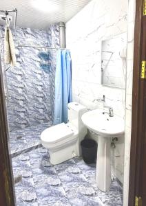 a bathroom with a toilet and a sink at Aziza Hotel White Tashkent in Yakkasaray +18 photos