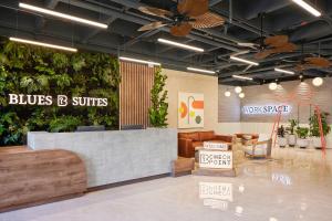 a blue b suites store with plants on the wall at Blues Suites Medellín in Medellín