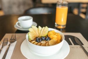 a bowl of fruit on a white plate on a table at Nodo Hotel in Manizales