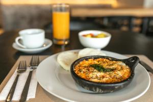 a black bowl of food on a plate on a table at Nodo Hotel in Manizales