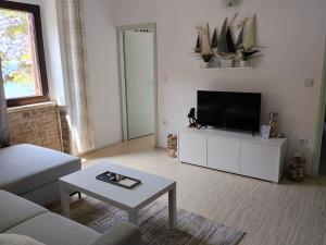 a living room with a flat screen tv on a white cabinet at Marko in Fažana