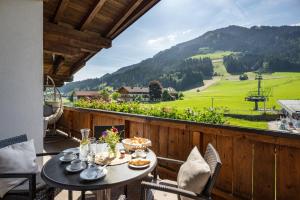 a table on a balcony with a view of a mountain at Apartment Anita in Westendorf