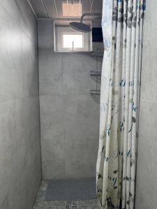 a shower with a shower curtain in a bathroom at "AlmUrUt" Guest House in Bokonbayevo