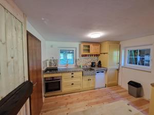 a kitchen with wooden cabinets and a counter top at Ferienhaus mit Bergblick am Wald in Stall +21 photos