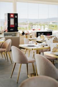 a dining room with tables and chairs and a kitchen at Eleia Domos - Aurea Rooms in Monopoli