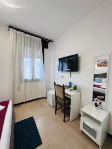 a living room with a bed and a desk and a television at Alisa house Venice in Venice