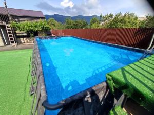 a large blue swimming pool with a green lawn at Eva Guesthouse in Odzun