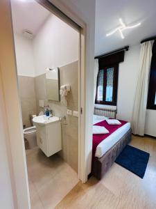 a bedroom with a bed and a bathroom with a sink at Alisa house Venice in Venice