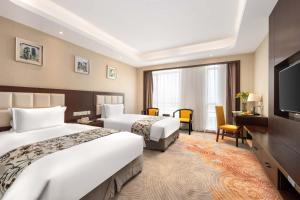 a hotel room with two beds and a flat screen tv at ShangHai LuAn Garden Hotel-Complimentary shuttle service between Shanghai Pu d ong Airport and Disneyland in Shanghai