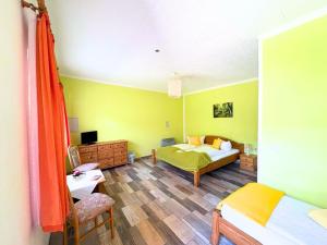 a room with a bedroom with a bed and a desk at Hotel-Pension Am Mühlberg in Lübbenau