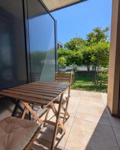 a wooden table and a chair on a patio at Studio Premium - Jardin privatif - Parking in Epalinges