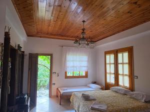 a bedroom with two beds and a wooden ceiling at LATE Nature House Gjirokaster in Gjirokastër