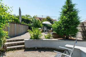 a garden with a bench and a table with an umbrella at Feriendomizil Brunnenberg in Sipplingen