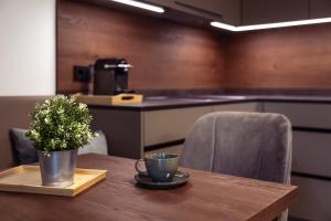 a table with two cups and a potted plant on it at Design Apartment Schladming in Schladming