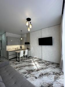 a kitchen with a table and a tv on a wall at SmartStudio in Odesa