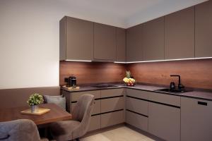 a kitchen with brown cabinets and a table and chairs at Design Apartment Schladming in Schladming