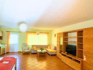 a living room with a couch and a tv at Hotel-Pension Am Mühlberg in Lübbenau +37 photos