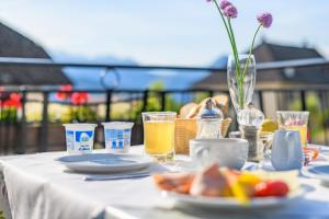 a white table with a plate of food and drinks at Micheli Hermann Obst- und Weinbauernhof mit "Südtirol Alto Adige Guest Pass - Mobilcard" in Caldaro