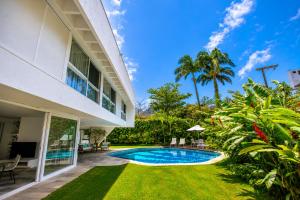 an exterior view of a villa with a swimming pool at Savay Hotel Boutique - Guarujá in Guarujá