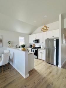 a kitchen with white cabinets and a stainless steel refrigerator at Tombstone Casa in Abilene