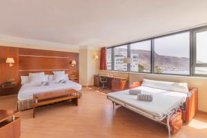 a hotel room with two beds and a desk at Moon Dreams Portomagno in Aguadulce