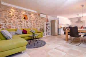 a living room with a green couch and a kitchen at Stone Villa Marjan in Pitve