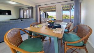 a living room with a wooden table and chairs at Paradise Beach Cottage #20 in Jeffreys Bay