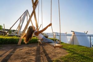 a young girl sitting on a swing at Kampaoh Ría de Vigo in Moaña +52 photos