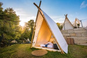 a teepee tent with a bed in the grass at Kampaoh Ría de Vigo in Moaña