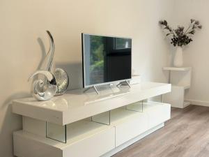 a white entertainment center with a tv on top of it at Wambacher Ferienwohnung in Schlangenbad