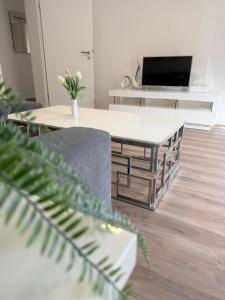 a living room with a table and a tv at Wambacher Ferienwohnung in Schlangenbad +6 photos